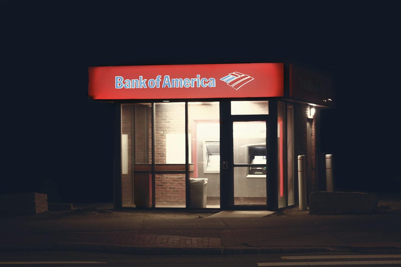 an atm machine on the side of the road during night time