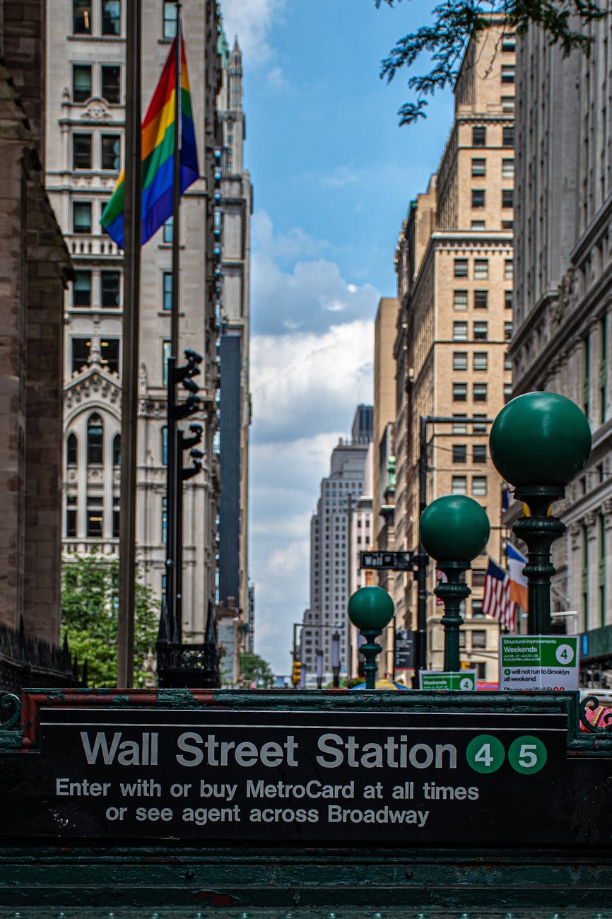 wall street station signage under blue sky